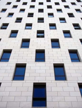 close up of a modern highrise apartment building with geometrical repeating windows and white claddingの写真素材