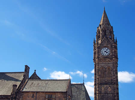 the tall clock tower of historic 19th century rochdale town hall in lancashire with blue summer sky and white cloudsの写真素材