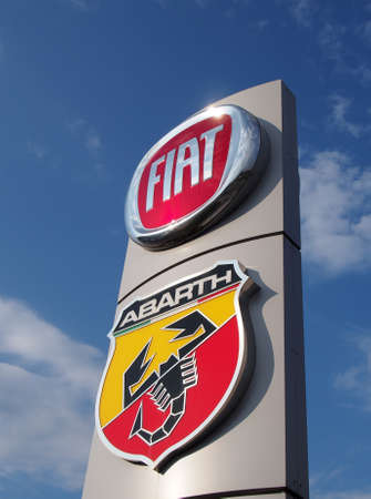leeds, west yorkshire, united kingdom - 25 august 2021: fiat and abarth symbols on a sign outside a...