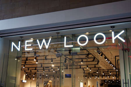 leeds, west yorkshire, united kingdom - 25 august 2021: sign above the entrance to the new look clothing store in albion street in leeds illuminated at nightのeditorial素材