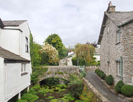 view of the bridge crossing the river with surrounding village houses in cartmel, cumbria