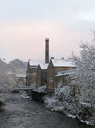 falling snow over the river calder in the west yorkshire town of hebden bridgeのeditorial素材