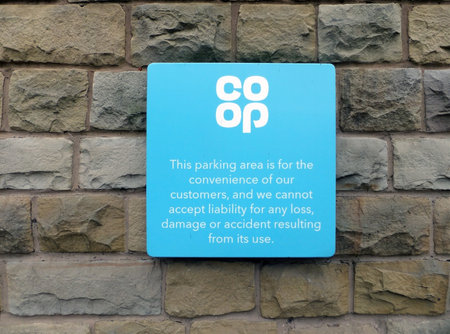 hebden bridge, west yorkshire, united kingdom - 20 may 2022: parking warning sign with logo on the wall of a coop supermarket in hebden bridgeのeditorial素材