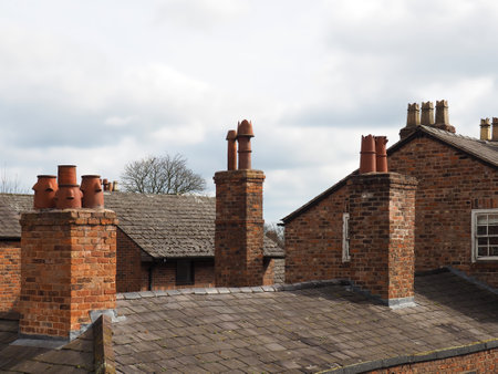 rooftop view of old british brick houses with slate roofs and tall chimneys in Chesterの写真素材