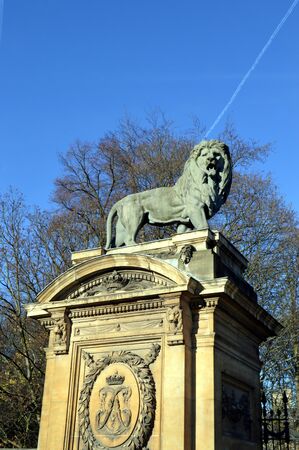 A sculptured lion on a pillar in front of a porticoのeditorial素材