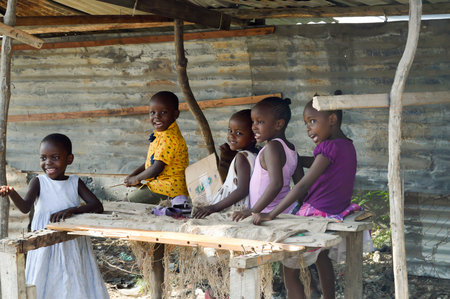 Five African youngsters smiling in a stall along the road from Bamburi to Kenyaのeditorial素材