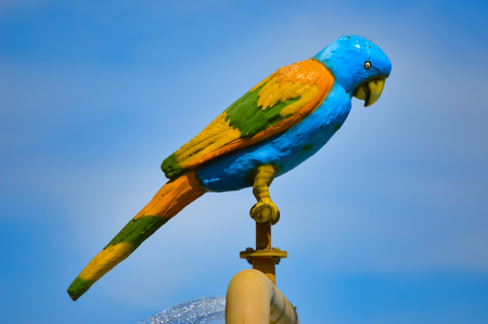 Statue of a parrot posing over a waterfallの写真素材