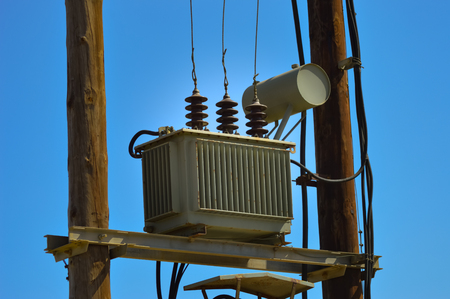 Electric transformer on wooden pylons with an arrival and several departures and countless...