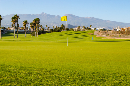 Green golf course facing the mountain and Teide volcano on the island of Tenerife in Spainの写真素材