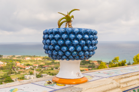 Pot of ceramic flowers in the shape of a half pinecone with a cactus in the city Santo Stefano di Camastra in the north of Sicilyの写真素材