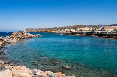 Entry the small port of Sissi with his taverns along the ocean and its lighthouse on the island of Crete in Greeceの写真素材