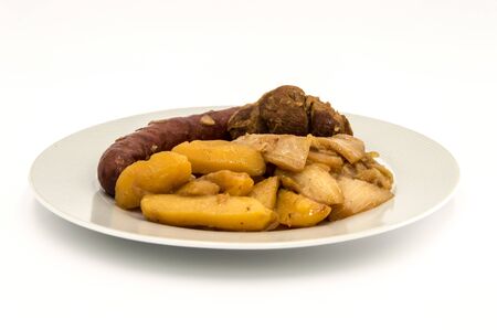 Plate of burnt white cabbage with sausage, potatoes and a piece of lamb on a white backgroundの写真素材