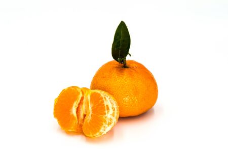 Ripe tangerine with leaves close-up on white background. Tangerine orange with leaves on white background.の写真素材