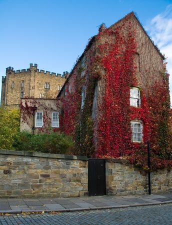 red ivy covered house with durham castle in backgroundの写真素材
