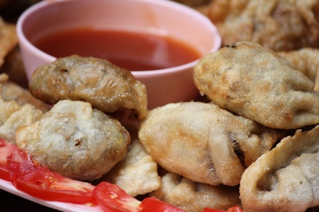 Pan-fried gyoza with dipping sauce and chopsticks on sideの写真素材