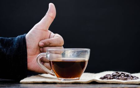 Drip coffee in a glass cup and hand thumpnail.の写真素材