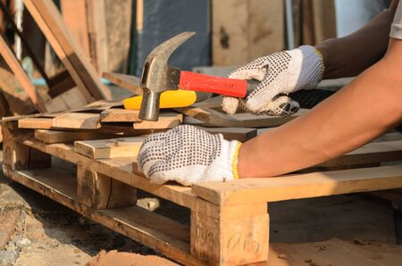 The carpenter is nailing the wood.の写真素材