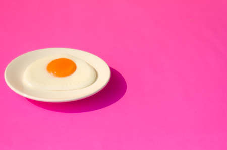 Fried egg , In white dish and plate on  pink table top.の写真素材