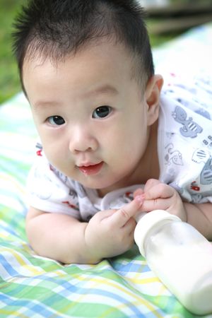 Baby holding bottle milkの写真素材