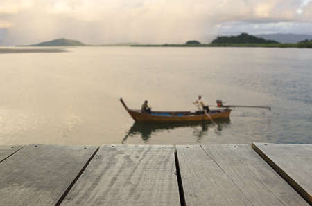 Defocus and blur image of terrace wood and fishermans in sea for background usageの写真素材