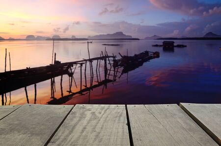 Defocused and blur image of terrace wood and beautiful seascape and fisherman in morning view for background usageの写真素材