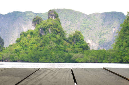 Defocus and blur image of terrace wood and Beautiful mountain midst of andaman sea for background usageの写真素材