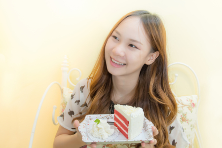 Beautiful girl eating cake in coffee shopの写真素材