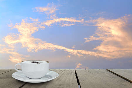 Cappuccino coffee on terrace wood over blue sky background in morning time