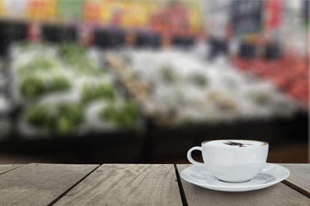 Defocus and blur image of Supermarket blur background with cappuccino coffee on terrace woodの写真素材