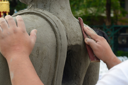 Artisan hands making clay buddha