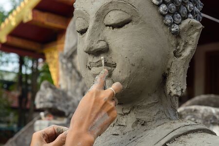Artisan hands making clay buddhaの写真素材