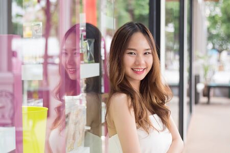 Asian beautiful girl leaning mirror and smileの写真素材