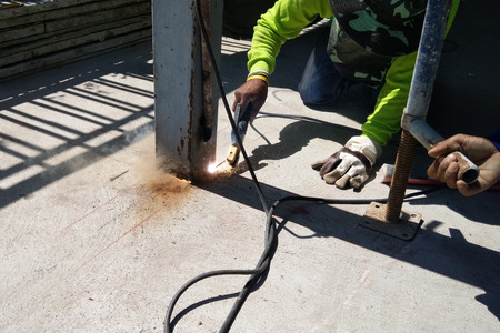 Construction worker cutting steel column by welder machine