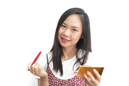 Asian woman applying red lipstick with cosmetic pencil on the lips - isolated on white backgroundの写真素材