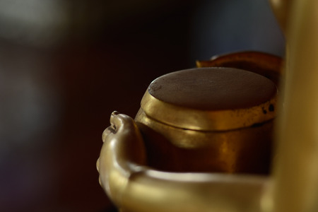 Hands of buddha holding monk's bowl as background