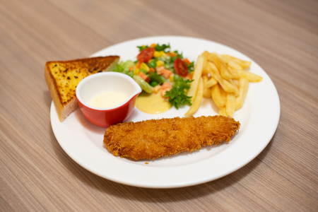 Fried salmon steak and appetizer on the tableの写真素材