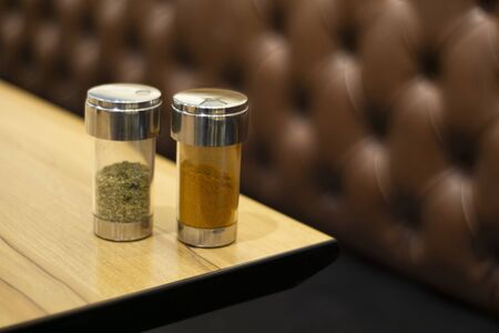 chilli flakes and oregano at a pizza shop on table.の写真素材