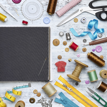 Overhead view of sewing tools and accessories on white painted wooden backgroundの写真素材