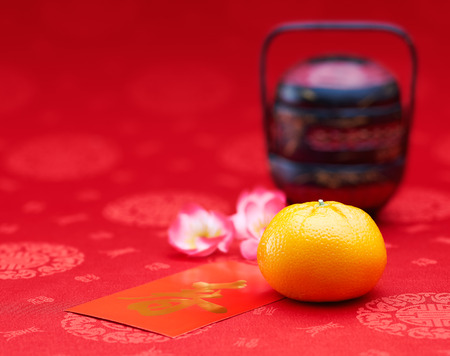 Chinese New Year - Mandarin orange and red packet (Foreign text means spring season)の写真素材