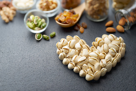 Pistachio nuts forming a heart-shape on slate backgroundの写真素材