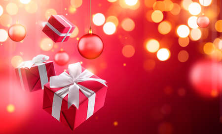 Christmas gifts with hanging bauble over blurred bokeh light backgroundの写真素材
