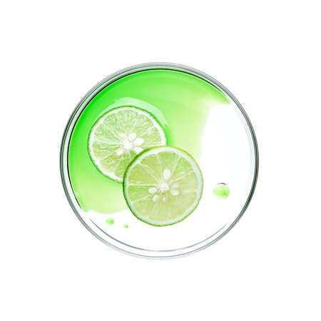 Sliced lime with essence on petri dish over white background