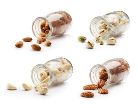 Nuts pouring out from bottle over white backgroundの写真素材