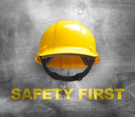 Yellow safety helmet on concrete wall backgroundの写真素材