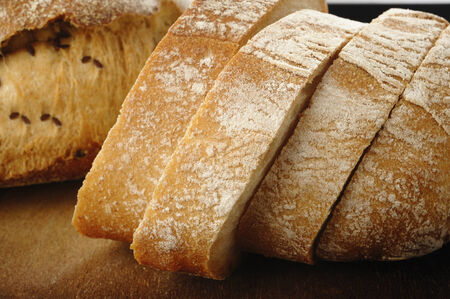 Sliced rustic bread on wooden background