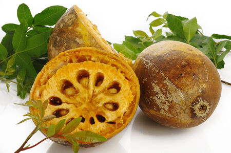 ripe bael fruit and leaf on white background