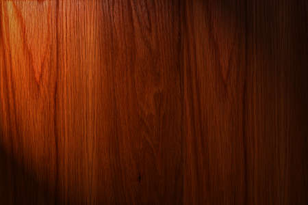 Dark brown wood background with light on the leftの写真素材