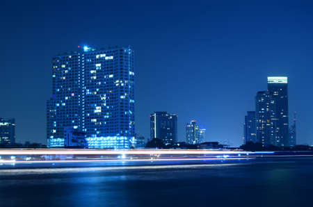 bangkok city skyline from the Chao Phraya River by night with Light passing