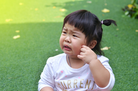 Close-up little girl crying in garden asian thailandの写真素材