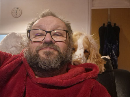 Spaniel with male owner on the sofaの写真素材